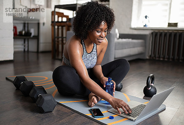 Schwarze Sportlerin benutzt Laptop in der Pause