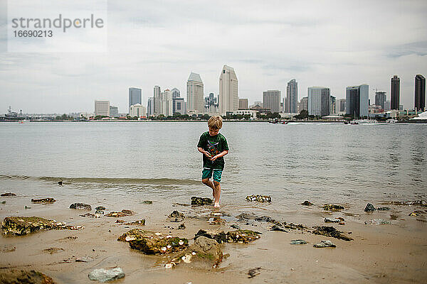 Sechs Jahre alter Junge  der in der Coronado-Bucht spielt  Skyline von San Diego