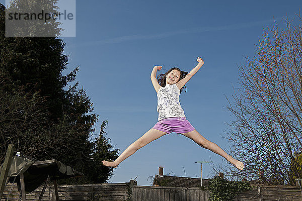 junges Mädchen springt auf einem Trampolin in Woking - England