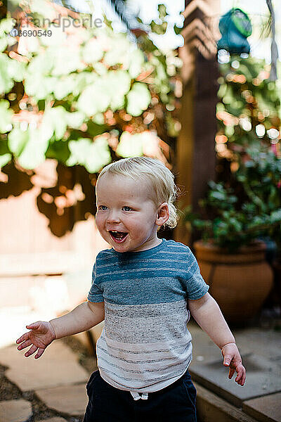 Ein Jahr alter Junge lacht im Hof in San Diego