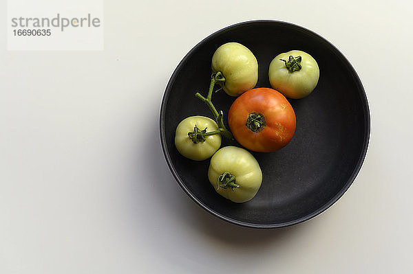 Minimalistische selbstgezogene Tomaten in schwarzer Schale
