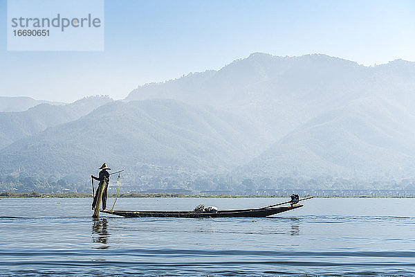 Fischer mit Fischernetz auf Boot vor Bergen  Inle-See  Nyaungshwe  Myanmar