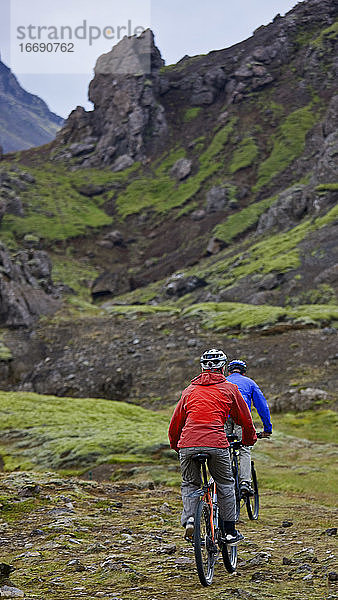 zwei Freunde fahren mit ihren Mountainbikes um den Thingvellir-See