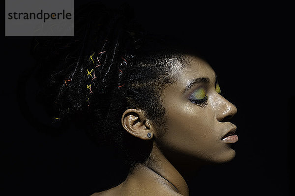 Interieur Hell-Dunkel-Porträt einer jungen schwarzen Frau