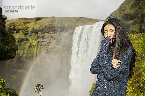 schöne Frau posiert am Skogarfoss-Wasserfall in Island