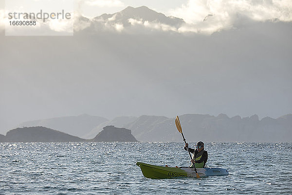 Eine Frau paddelt auf einem Sitz auf dem Kajak in der Nähe des Ufers der Insel Carmen in Loreto  Baja California  Mexiko.