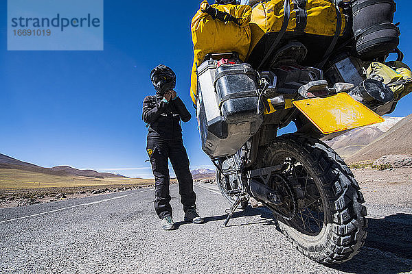Frau  die sich auf eine Fahrt mit ihrem Tourenmotorrad in Chile vorbereitet