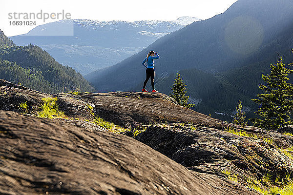 Eine starke Sportlerin macht eine Pause vom Laufen während eines Fitnesstrainings in der Natur bei Sonnenuntergang.