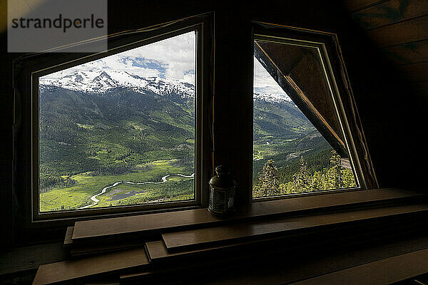 Berge und grünes Tal hinter dem Hüttenfenster