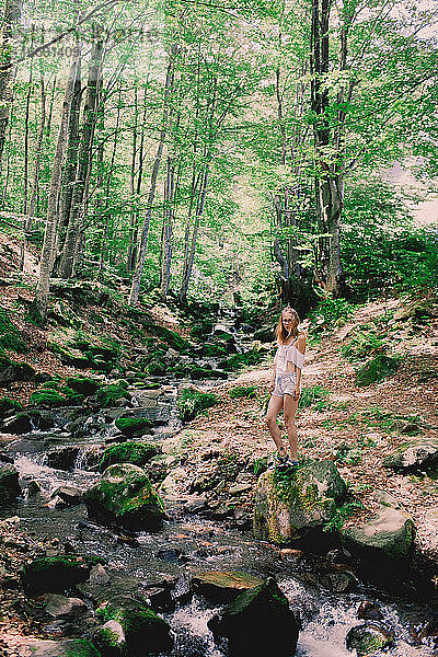 Happy Tourist Mädchen Teenager im Wald in der Nähe der kalten frischen Strom Fluss am Wasserfall Shypit  Kaskade in Pylypets im Wald. Karpaten