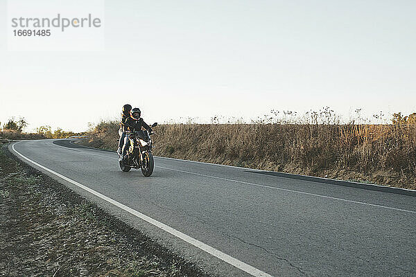 Motorrad fahrendes Paar auf der Straße
