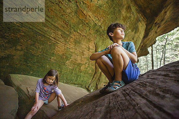 Zwei Kinder spielen zusammen auf einem Felsvorsprung in einer Sandsteinschlucht