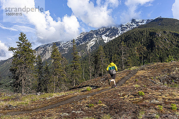 Der Mann läuft auf einem malerischen alpinen Bergpfad in British Columbia.
