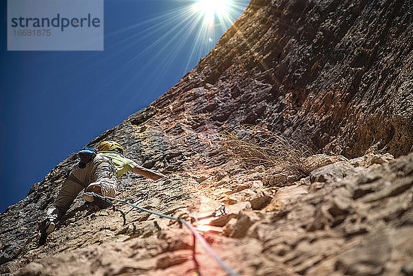 Bergsteiger aus einem niedrigen Blickwinkel mit Sonnenreflexionen