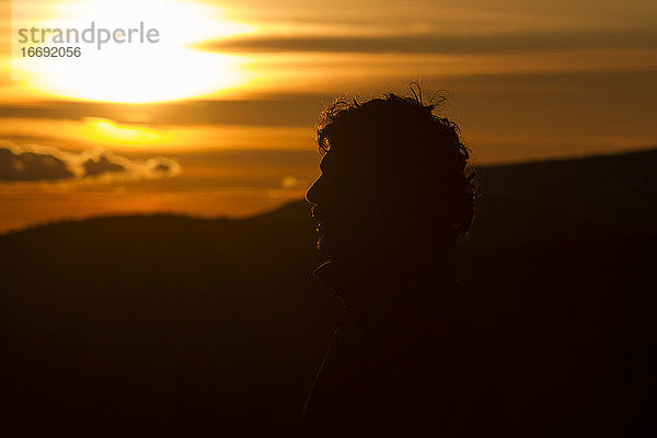 Silhouette des Kopfes eines Mannes bei Sonnenuntergang