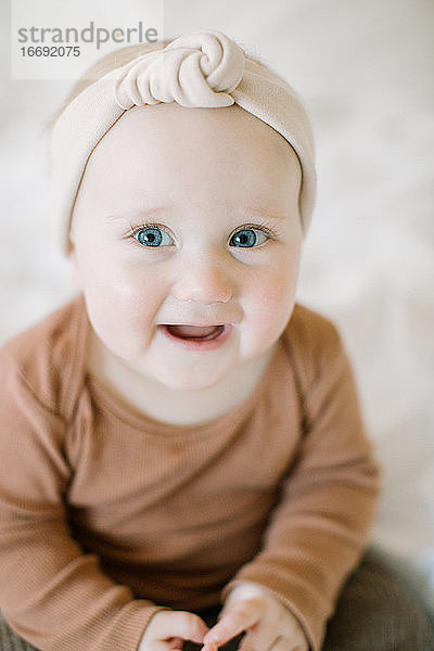 Nahaufnahme von Baby-Mädchen lächelnd in die Kamera mit großen blauen Augen
