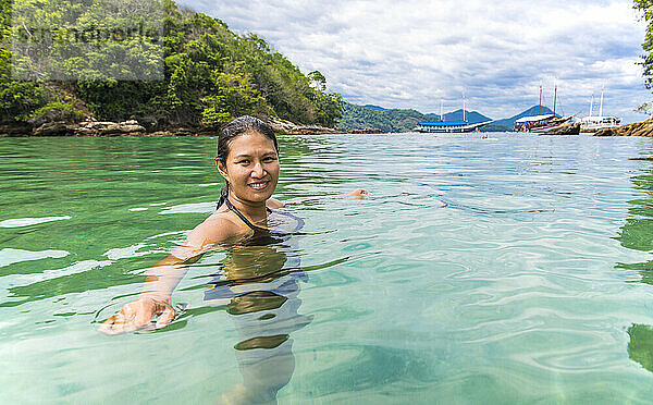 Frau beim Schwimmen in der grünen Lagune auf der tropischen Insel Ilha Grande