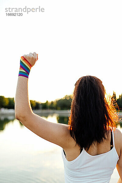 Frau auf dem Rücken mit einem Streifen der Gay Pride Flagge am Handgelenk