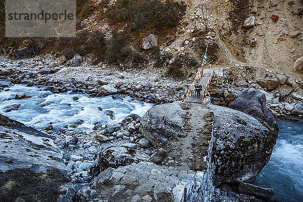 Ein Sherpa-Träger überquert eine Brücke im Khumbu-Tal in Nepal.