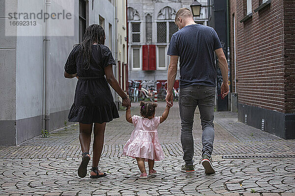 Eine junge Familie geht durch die Straßen einer europäischen Stadt