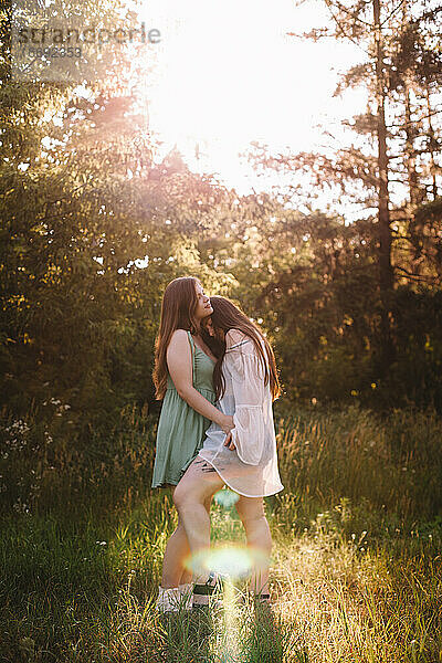 Lesbisches Paar turtelt im Sommer im Wald