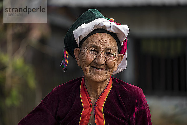 Porträt einer lächelnden älteren Frau vom Stamm der Palong mit Kopfbedeckung  in der Nähe von Hsipaw  Myanmar