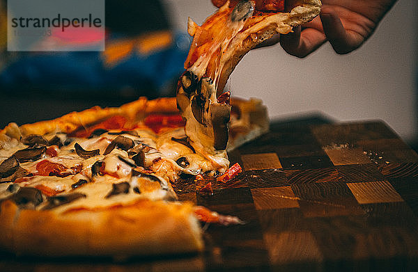 Selektiver Fokus auf italienische Pizza  Gewürze in Mühlen  Flasche und Glas Wein auf Holztischplatte