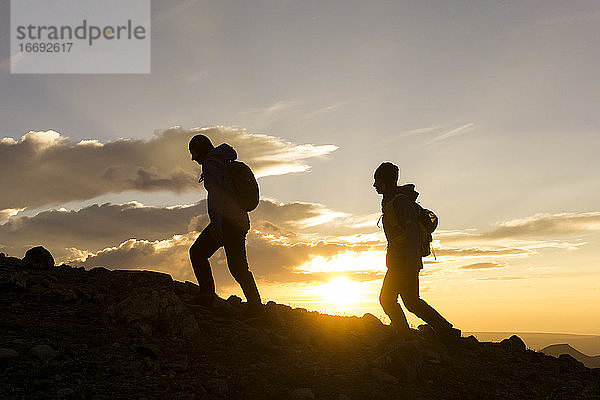 Silhouette weibliche Wanderer auf Berg gegen Himmel während Sonnenaufgang