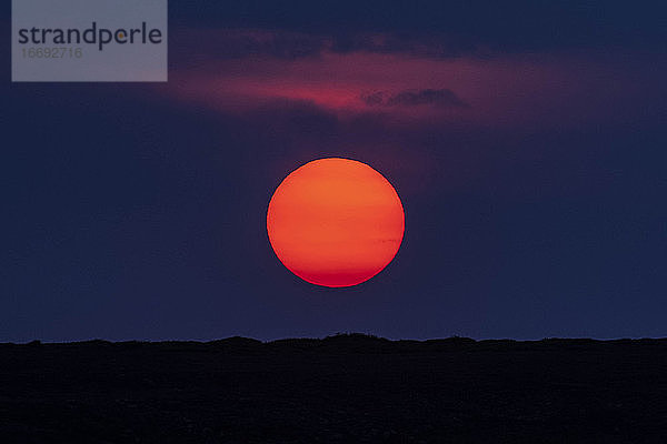 Idyllische Aufnahme von orangefarbenen Mond über Silhouette Landschaft