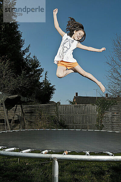 junges Mädchen springt auf einem Trampolin in Woking - England