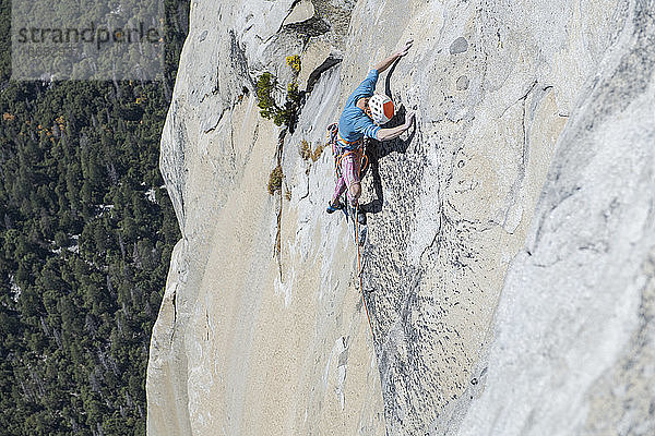 Kletterer blickt auf seine Füße hoch oben auf dem ausgesetzten El Capitan hinunter