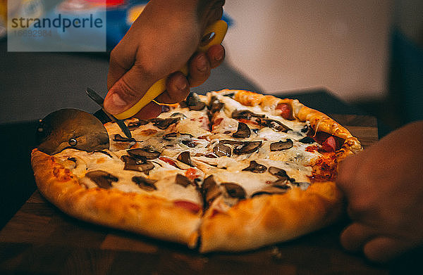 Selektiver Fokus auf italienische Pizza  Gewürze in Mühlen  Flasche und Glas Wein auf Holztischplatte