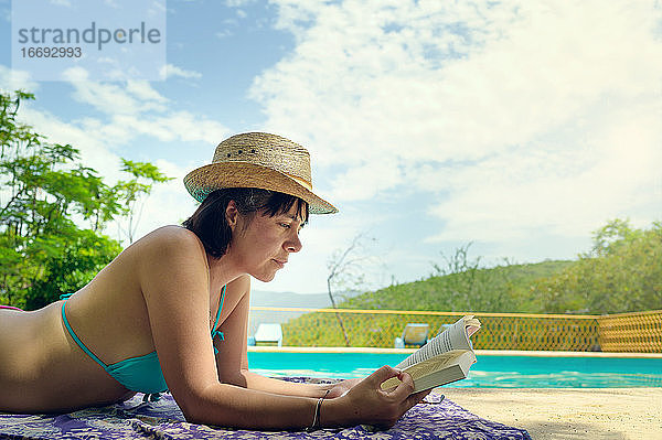 Frau beim Lesen und Entspannen im Luxus-Swimmingpool. Entspannender Urlaub