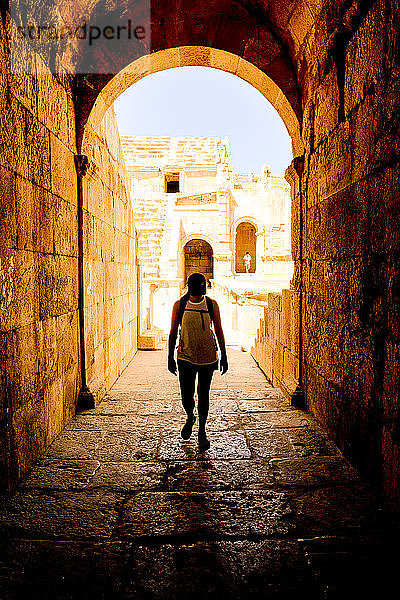 Frau geht unter einem Bogen in der alten römischen Stadt Jerash  Jordanien