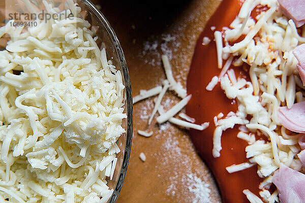 Bei der Zubereitung des Pizzabodens zu Hause legen wir Tomaten  Käse ...