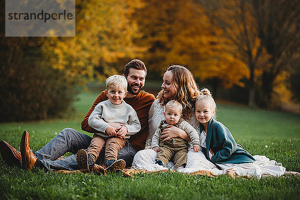 Schöne Familie in einem Park lächelnd an einem Herbsttag