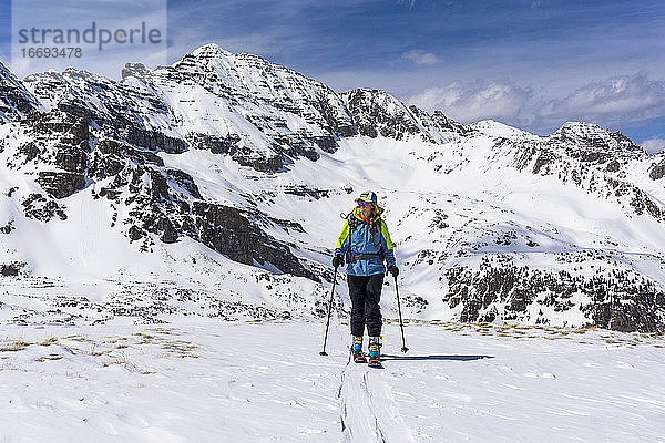 Wanderin beim Splitboarding gegen schneebedeckten Berg