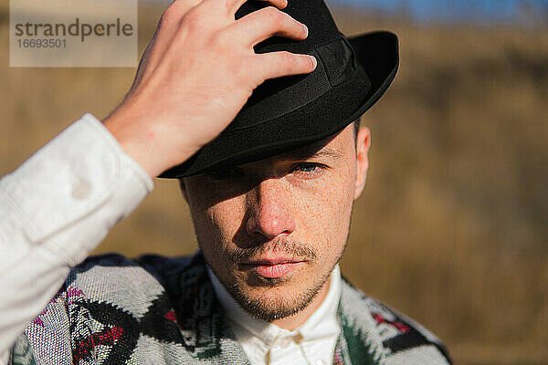 Kaukasischer Mann mit Hut posiert in einer ländlichen Gegend der Ukraine
