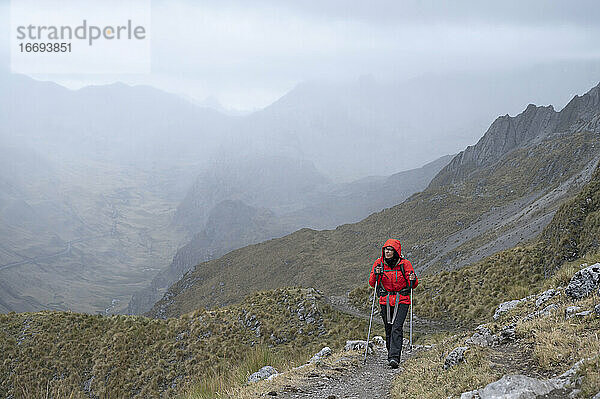 Eine Person mit Stöcken auf einem Wanderweg in der Cordillera Huayhuash