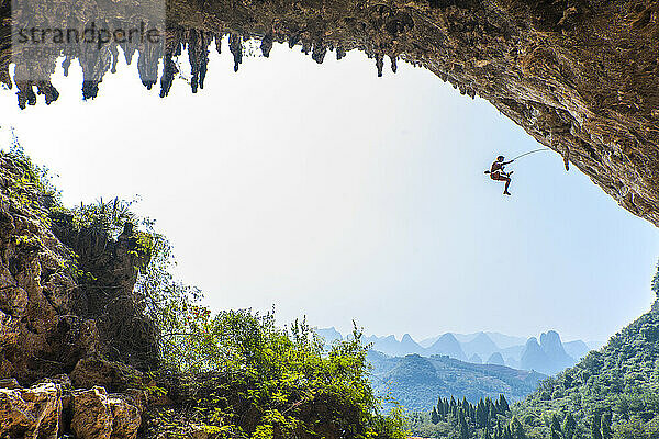 Mann beim Klettern in Odin's Den in Yangshuo  einem Klettermekka in China