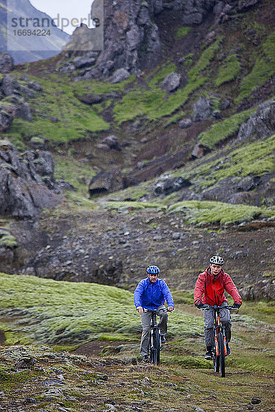 zwei Freunde fahren mit ihren Mountainbikes um den Thingvellir-See