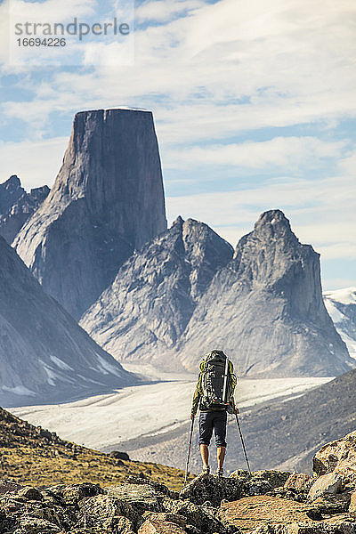 Rückansicht eines Rucksacktouristen  der sich dem Mount Asgard Akshayak Pass nähert  Kanada