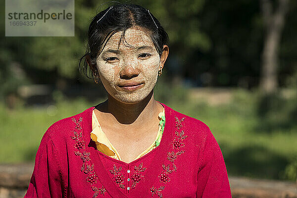 Junge Frau mit Thanaka im Gesicht an einem sonnigen Tag  Inwa  Mandalay  Myanmar