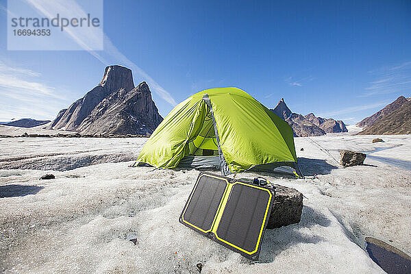 Solarmodul-Ladegerät mit Zelt im Hintergrund auf einem abgelegenen Campingplatz