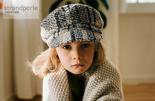 Porträt eines kleinen Kindes mit Hut und ernstem Blick