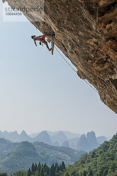 Mann beim Klettern in Odin's Den in Yangshuo  einem Klettermekka in China