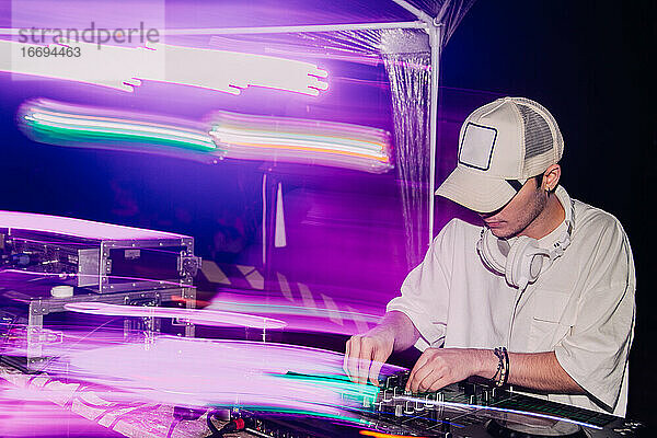 Club  Disco-DJ spielt und mischt Musik für die Menge der glücklichen Menschen. Nachtleben  Konzert Lichter  Fackeln