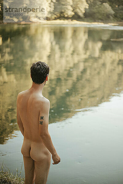 Rückenansicht eines nackten Mannes am Fluss
