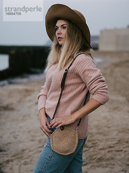 Mädchen mit Hut auf dem Meer mit einem handgefertigten Jutebeutel