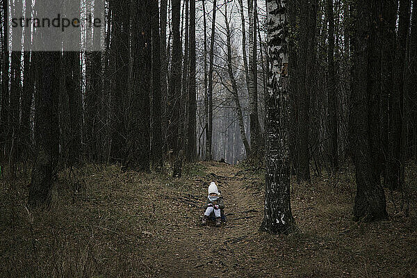 Kleines Kind allein im Herbstwald.